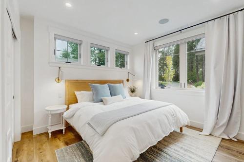 a white bedroom with a large bed and windows at StillWater Retreat in Dover