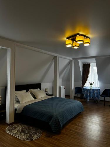 a bedroom with a large bed and a chandelier at Готель Сузірʼя in Kolomiya