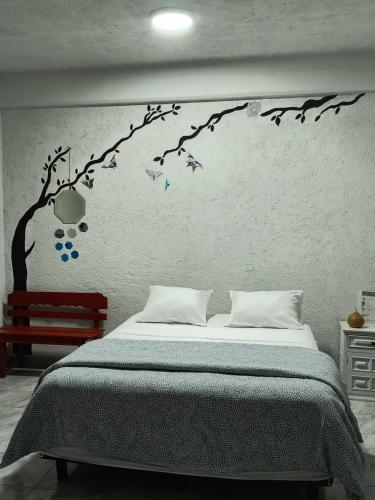 a bedroom with a tree branch with birds on it at Casa Tonatih in Mexico City
