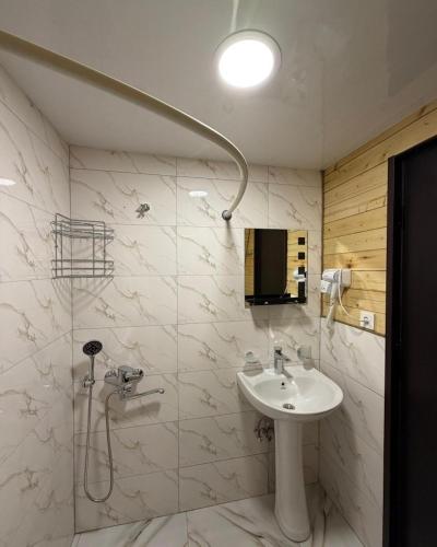 a white bathroom with a sink and a shower at Sno Valley Cottage in Sno