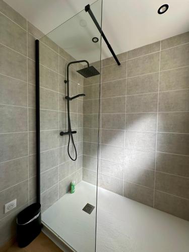 a shower with a glass door in a bathroom at Maison avec jardin à 5 min à pied de la plage, clim et parking in Royan