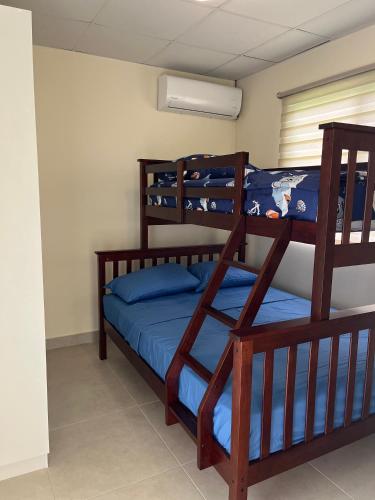 a bedroom with two bunk beds with blue sheets at The Sailor beach House Just 35 Minutes from Panama City! in Vacamonte