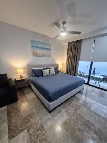 a bedroom with a blue bed and a balcony at Tu estancia perfecta - ubicación y privacidad in Playa del Carmen