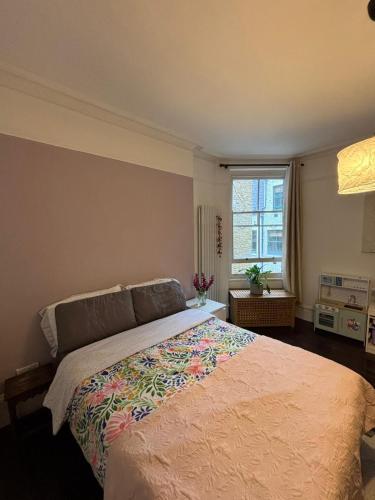 a bedroom with a large bed and a window at Spacious Flat in West Kensington in London