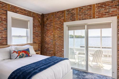 a bedroom with a bed and a brick wall at North Hero House Inn and Resort in North Hero