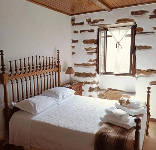 a bedroom with a large bed with a window at Casa dos avós 23 in Castro Daire