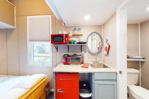 a small kitchen with a sink and a bed at Tiny Homes on Pleasant in Ludlow