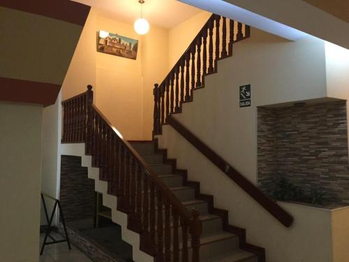 a spiral staircase in a house with a brick wall at Hotel Faraon in Tacna