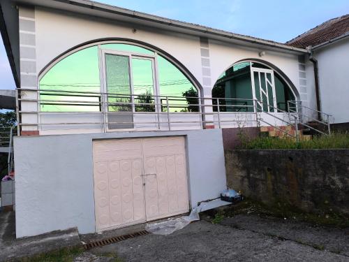 a house with a pink door and a balcony at Elan apartmani in Bar