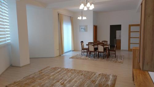 a dining room and living room with a table and chairs at Orges Apartament in Struga