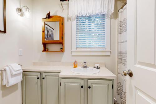 a white bathroom with a sink and a window at Teddy's Getaway in Ludlow