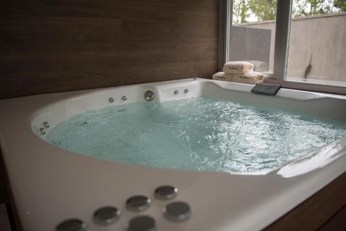 a bath tub filled with a blue water at Nova pampa apart&spa in Mar de las Pampas