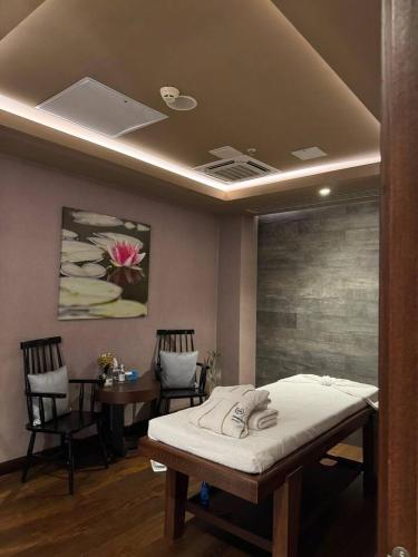 a hospital room with a bed and a table and chairs at Sheraton Apartments in Bishkek