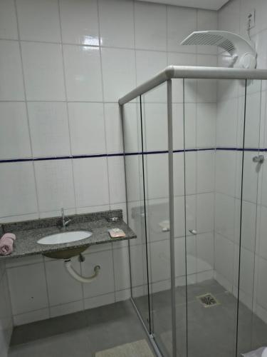 ein Badezimmer mit Glasdusche und Waschbecken in der Unterkunft Kitnet NOMAD in Barão de Cocais
