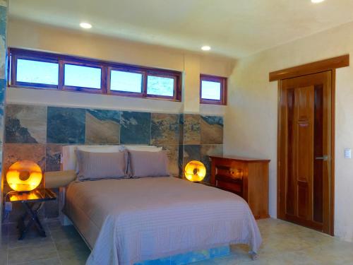 1 dormitorio con 1 cama y 2 luces en una mesa en Hotel Casa Maya Calakmul, en Chicanna