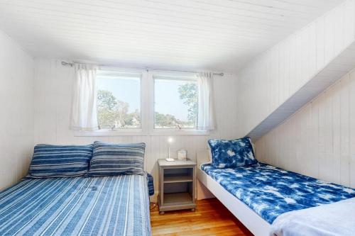 a bedroom with two beds and a window at Black Cove Cottage in Manchester