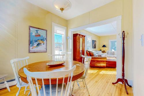 a dining room with a table and chairs and a bedroom at A Villager's Dream in North Conway