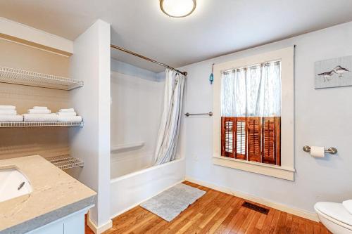 a bathroom with a sink and a toilet and a window at Cool Change in Hampton