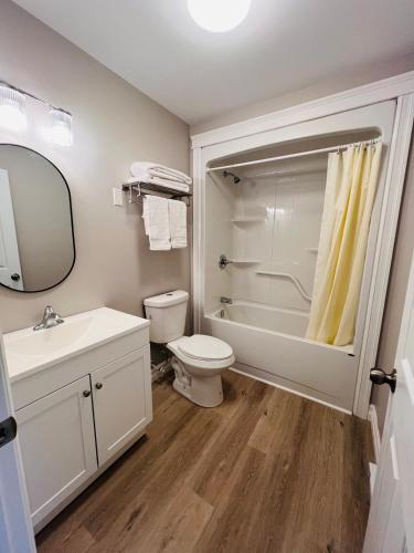 a bathroom with a toilet and a sink and a shower at SUMMERSIDE MOTEL &COTTAGES in Summerside