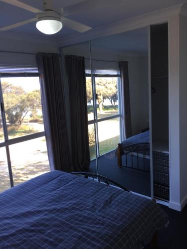 a bedroom with a bed and a large window at Falcon Bay 4x4 Townhouse in Wannanup