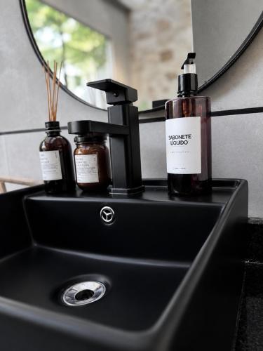 a bathroom sink with two bottles on it at Luce del sole bangalô in Fortim