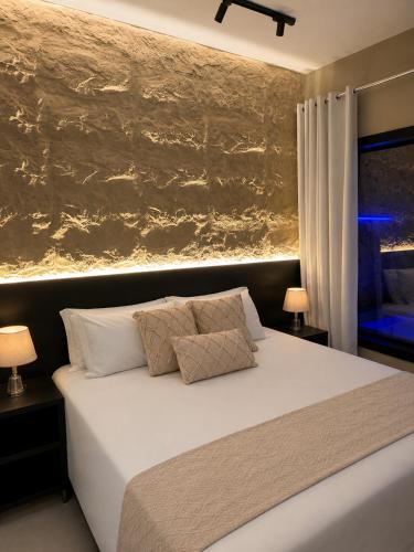 a bedroom with a white bed with a painting on the wall at Luce del sole bangalô in Fortim