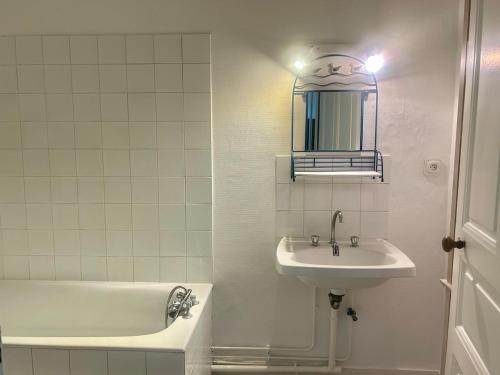 a bathroom with a sink and a tub and a mirror at Studio -Center - Lorient in Lorient