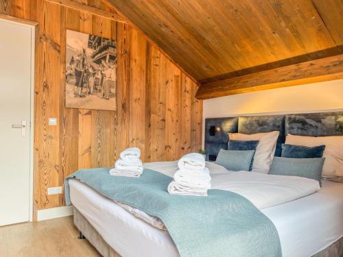 a bedroom with a large bed with wooden walls at Alpenzeit Afritz am See in Afritz