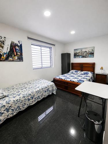 a room with two beds and a table in it at Hotel Siglo 21 in Cali