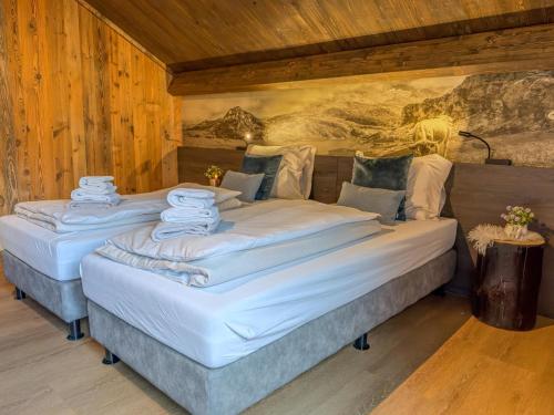 two twin beds in a room with wooden walls at Nockberge in Afritz