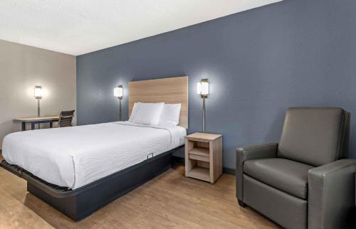 a bedroom with a bed and a chair in it at Extended Stay America Select Suites - Longview in Longview