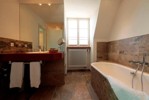 a large bathroom with a tub and a sink at Krone Langenburg by Ammesso in Langenburg