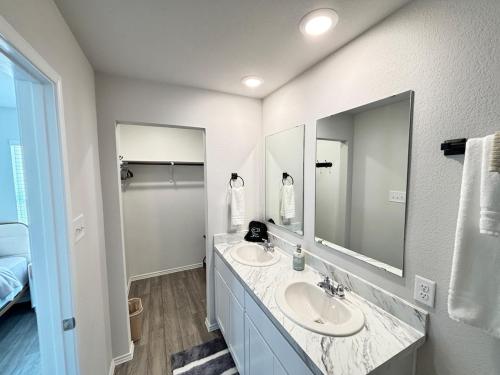 a bathroom with two sinks and a large mirror at Quiet at Pine Branch in Lufkin