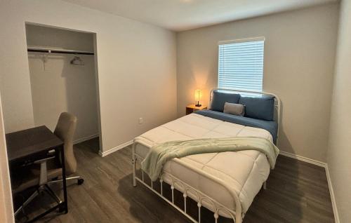 a bedroom with a bed and a desk and a window at Quiet at Pine Branch in Lufkin