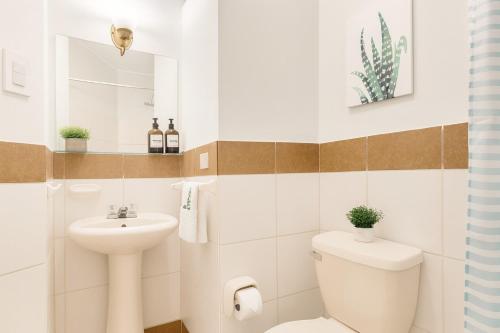 a white bathroom with a toilet and a sink at Room in shared apartment - Shared Bathroom 402 in Lima