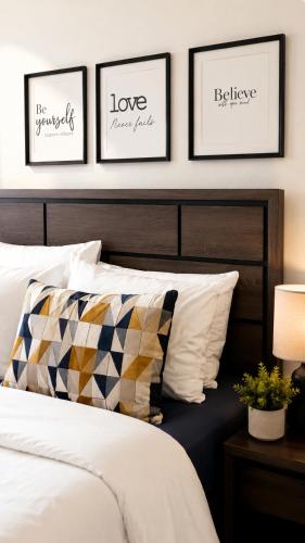 a bedroom with three framed pictures above a bed at Glenmuir La Ville - Gated Com May Pen in May Pen