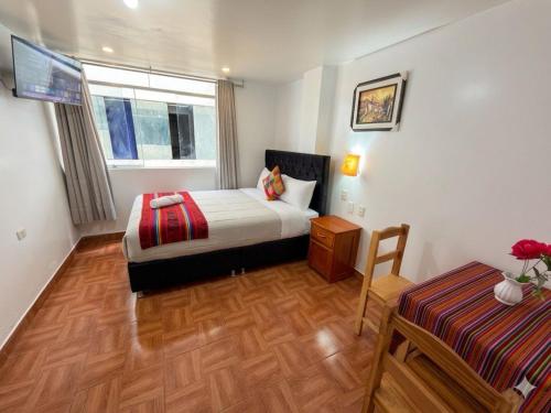 a bedroom with a bed and a table in a room at Machu Picchu Sacred Valley in Machu Picchu