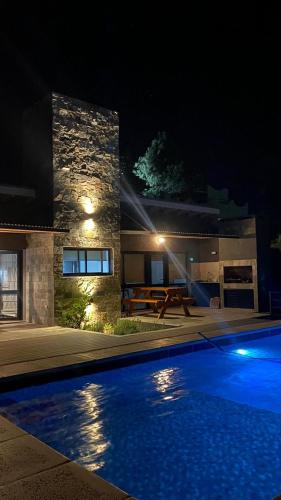 a swimming pool in front of a house at night at Trovare un Senso in Capilla del Monte