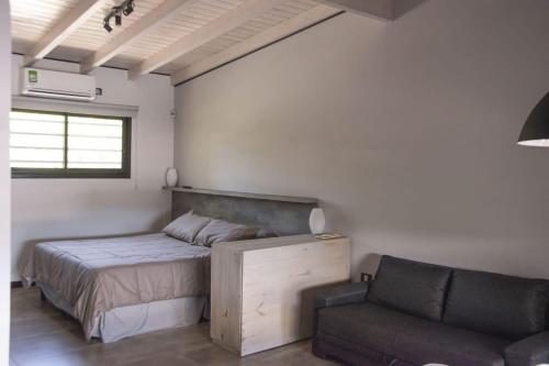 a bedroom with a bed and a chair at Trovare un Senso in Capilla del Monte