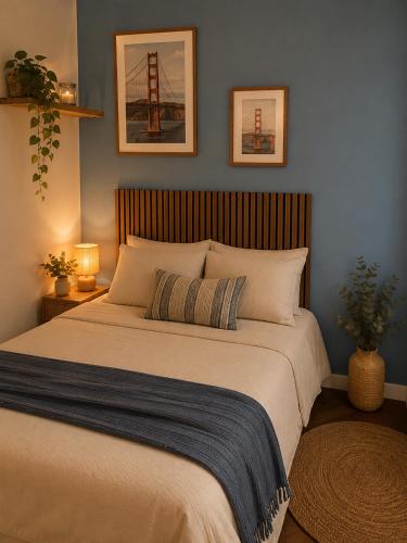 a large bed in a bedroom with two pictures on the wall at Le Refuge de Chateau Renard in Château-Renard