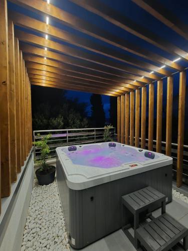 a jacuzzi tub on a deck with lights at Apartment Jasna in Splitska