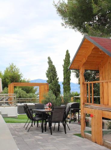 a wooden pavilion with a table and chairs on a patio at Apartment Jasna in Splitska