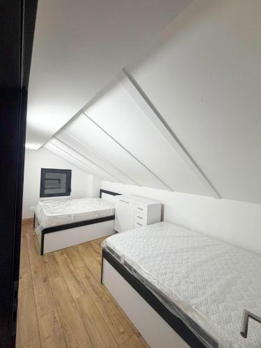 two beds in a room with a attic at Villa NOA in Bijeljina