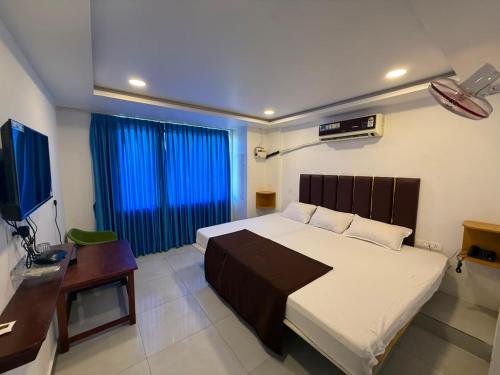 a bedroom with a bed and a desk and a television at Arlinjai Paradise in Kanyakumari