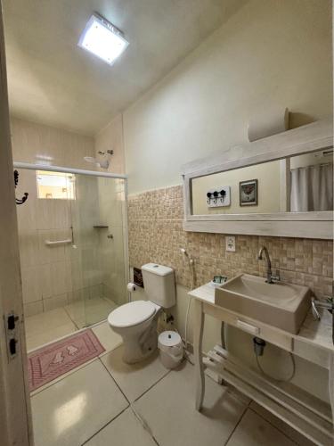 a bathroom with a toilet and a sink and a shower at Pousada Anturio Centro in Barra Velha