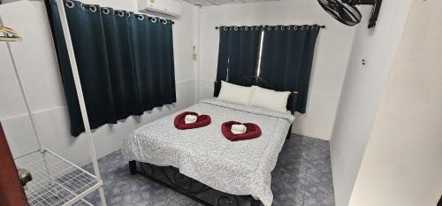 a bedroom with a bed with two red hearts on it at Ao Nang Room And Bike 10 in Ao Nang 
