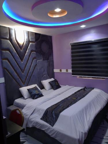 a bedroom with a large bed with a blue light at Emmydon Hotel And Suites in Enugu