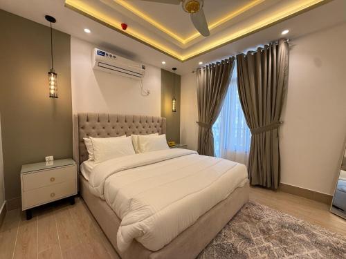 a bedroom with a large bed and a window at 2 BHK Stayloom 218 in Rawalpindi