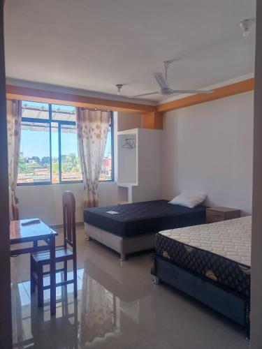 a bedroom with two beds and a table and chairs at Hospedaje Luciana in Pucallpa