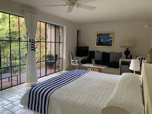 a bedroom with a bed and a living room at Il Piccolo Peccato in Cuernavaca